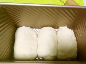 将卷好的面团放入模具内，放烤箱二次发酵，烤箱内放碗热水