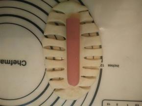 将两边分别用刀割出1厘米宽的面条，中间留着放香肠，如图。