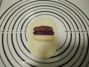 取一个油皮，用手掌压扁，用擀面杖横着擀一下，然后再竖着擀开，擀成长方形，再将三色油酥放在油皮中间。