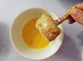 裹好面粉的鸡翅根放在鸡蛋液中，使其表面沾满鸡蛋液。