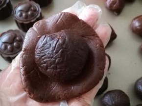 巧克力皮在手上按压成薄片，包入一个巧克力馅，滚圆。