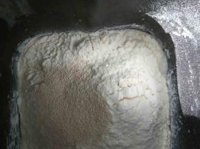 除黄油和紫薯泥外，所有材料放入面包机内，启动和面程序揉成光滑的面团。加入软化好的黄油，揉到扩展阶段即可