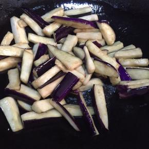 热锅，加入适量食用油。油温升高后加入茄子，炒至变软。