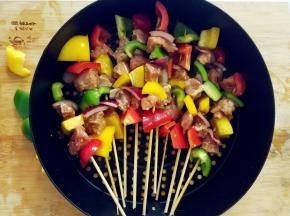 串好的肉串刷上剩余的酱料，排放在炸篮中。