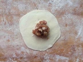 取适量馅，放在饺子皮中间。