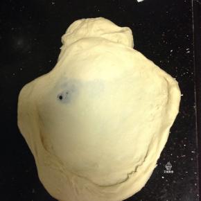 揉成大片有韧性的膜加入黄油和盐继续揉匀，开始摔打面团。