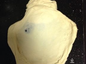 揉成大片有韧性的膜加入黄油和盐继续揉匀，开始摔打面团。