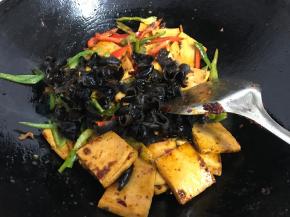 放入黑木耳、青、红椒翻炒均匀至断生。