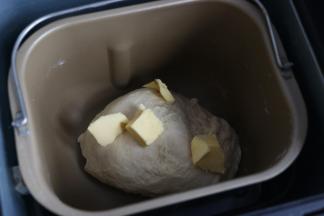 20分钟后加入软化的黄油，继续揉面。