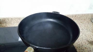 9.中大火将厚底的铸铁锅烧热，烧至冒烟。