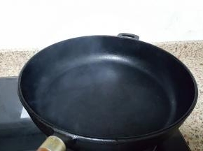 9.中大火将厚底的铸铁锅烧热，烧至冒烟。