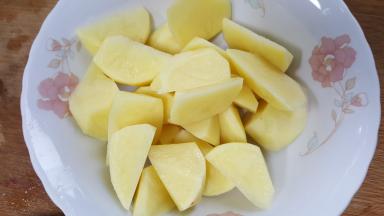 7.两个土豆去皮切滚刀块备用。