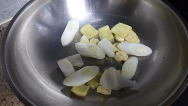 12.油热后放入葱姜蒜爆香。