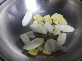 12.油热后放入葱姜蒜爆香。