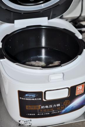 排骨捞出后，用温水冲洗干净，放入电压力锅内胆中，加足够的冷水。