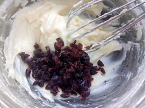 蔓越莓干剪碎些，再用清水洗一下控干水，放入奶酪里拌匀备用。