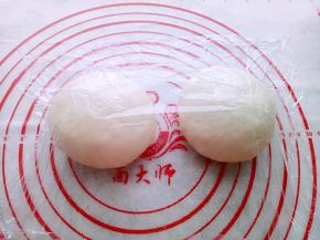 取出面团排气后，平均分成2份，滚圆盖保鲜膜松弛20分钟。