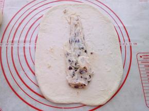 两个面团依次用擀面杖擀开放入蔓越莓奶酪馅卷起来。