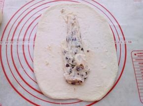 两个面团依次用擀面杖擀开放入蔓越莓奶酪馅卷起来。