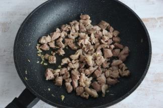 羊肉变色后，加入少许料酒，继续翻炒。