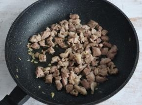 羊肉变色后，加入少许料酒，继续翻炒。