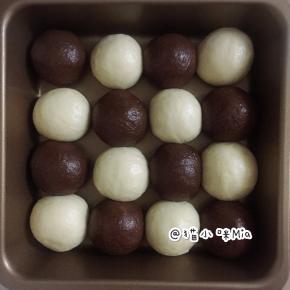 松弛好的面团再次排气，揉圆，分别错落地放进一个20cm的正方形不沾烤盘