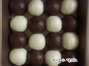 松弛好的面团再次排气，揉圆，分别错落地放进一个20cm的正方形不沾烤盘