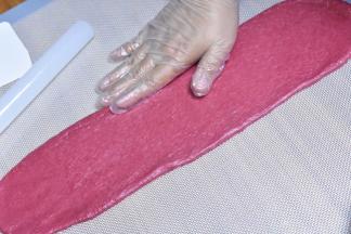 擀成瘦长条儿，手掌按压边缘，按出气泡。