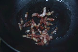 继续放入腊肠，放入小许蒜香翻炒爆香