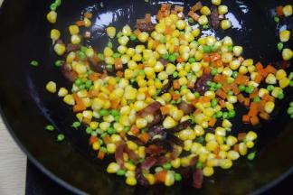 放入青豆，玉米粒和萝卜粒翻炒2分钟左右；炒拌均匀