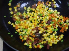 放入青豆，玉米粒和萝卜粒翻炒2分钟左右；炒拌均匀
