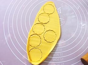 将面条擀开成薄皮，用磨具压花，将多余的面团揉圆擀开成薄皮压花