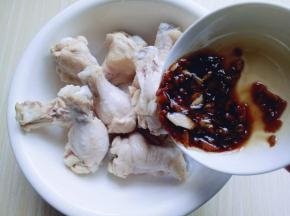 焯好的鸡翅根加入大一点的器具中，将腌料倒入。