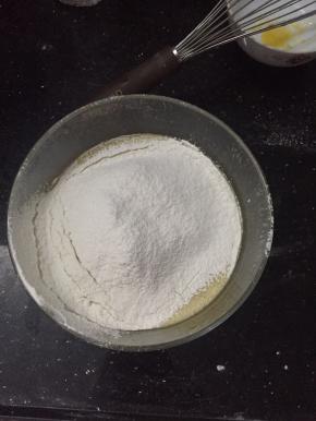 将泡打粉，低粉，盐混合过筛加入鸡蛋液中，搅拌至没有颗粒。