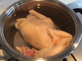 准备一锅清水，锅里水烧开后，关火，然后把洗干净的鸡整个没入锅中，开小火，保持锅里的水不要烧开