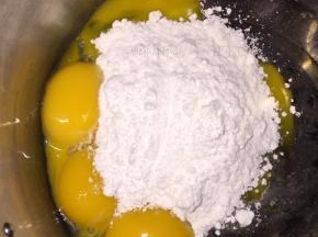 将蛋黄、细砂糖倒入一个盆中，用电动打蛋器打至体积变大，颜色偏淡发白
