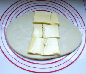 3、把面团擀成长方形，包入100g黄油