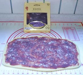 7、松弛好以后擀成4mm左右厚的长方形，表面铺上紫薯泥馅，再撒上白砂糖。