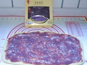7、松弛好以后擀成4mm左右厚的长方形，表面铺上紫薯泥馅，再撒上白砂糖。