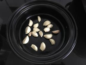 把剥好的大蒜放入酒精炉锅中。