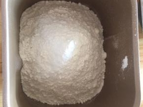 先将面粉倒入面包机桶