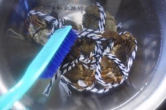 将大闸蟹用刷子清洗干净，注意不要把绳子解开