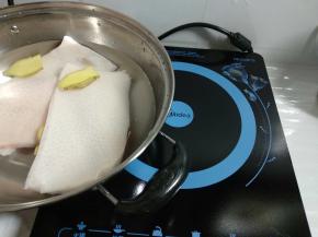 猪皮洗净和姜片放入锅里，加入淹过猪皮的水，放置美的电磁炉上。