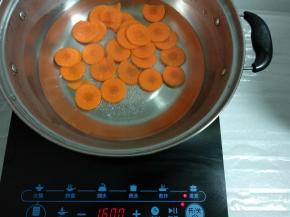 锅里注入适量清水放置美的电磁炉上，将胡萝卜煮熟捞出备用。