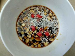 蒜蓉放入碗里加入酱油，醋，芝麻和辣椒调成酱汁。