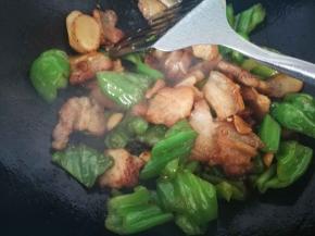 青椒变软，倒入料酒，生抽，老抽，翻炒