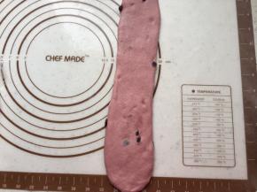 取一个面团擀开，拍掉周围气泡。翻面，自上向下卷起