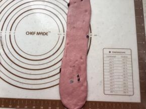 取一个面团擀开，拍掉周围气泡。翻面，自上向下卷起