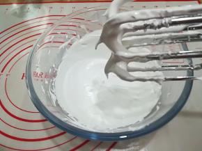 6. 将糖水慢慢倒入已打发好的蛋白中，边倒边用打蛋器搅打，打至蛋白霜降到40度左右