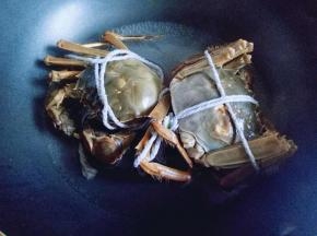 将蟹放入平底锅中，加入少量水，大火烧开，使大闸蟹死掉即可。
